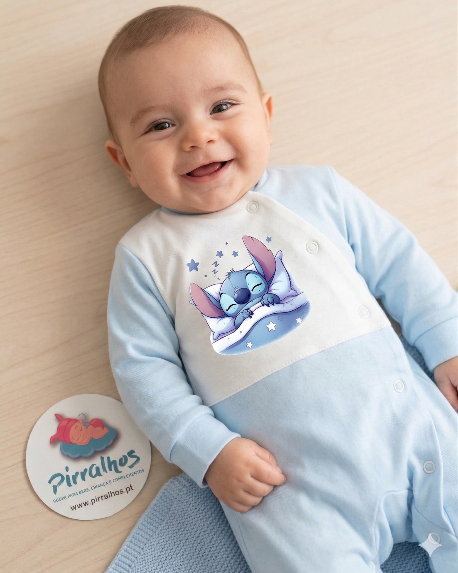 Babygrow azul e branco com estampa do Stitch a dormir e etiqueta redonda ao lado
