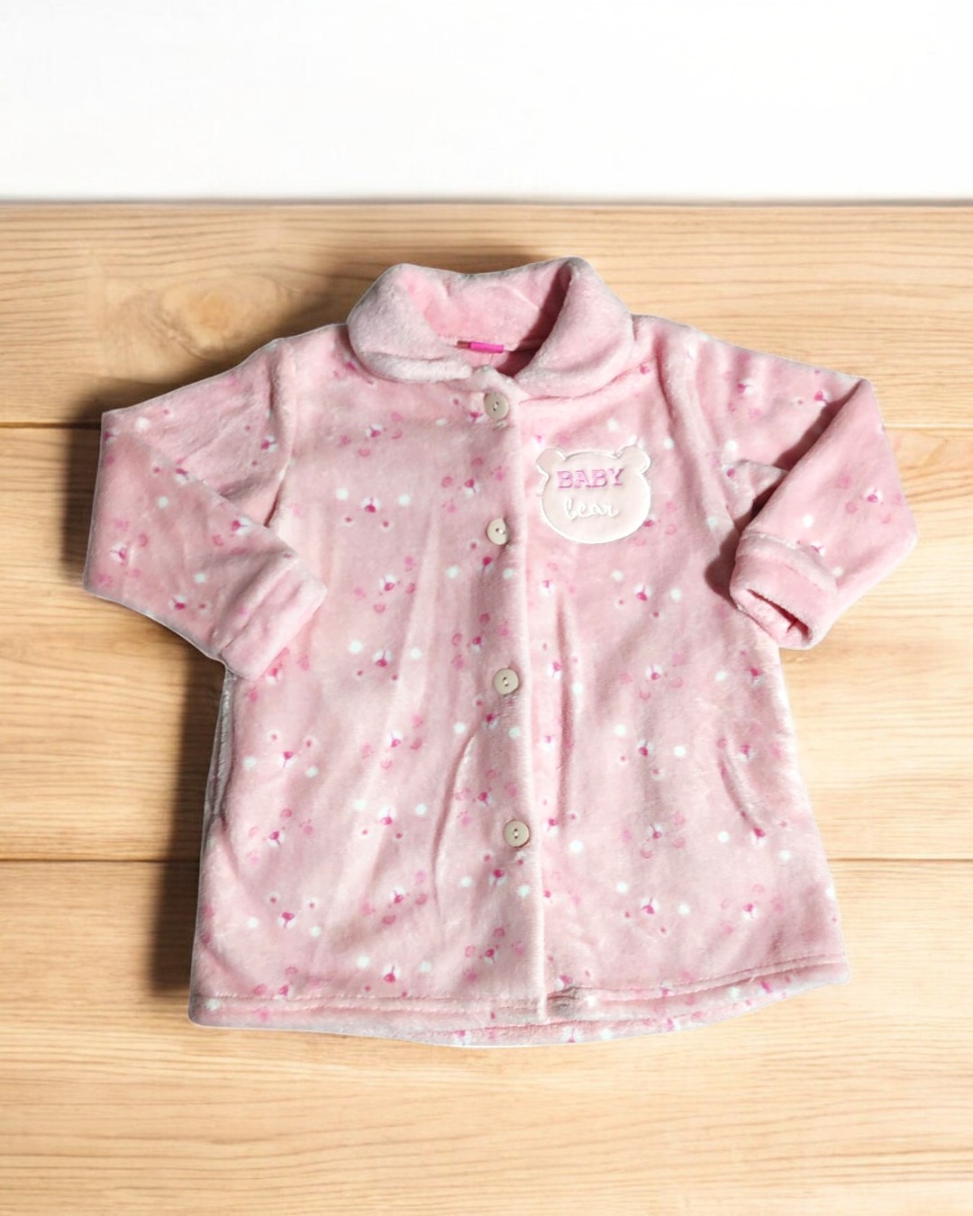 Casaco de bebé rosa claro com botões e padrão de flores