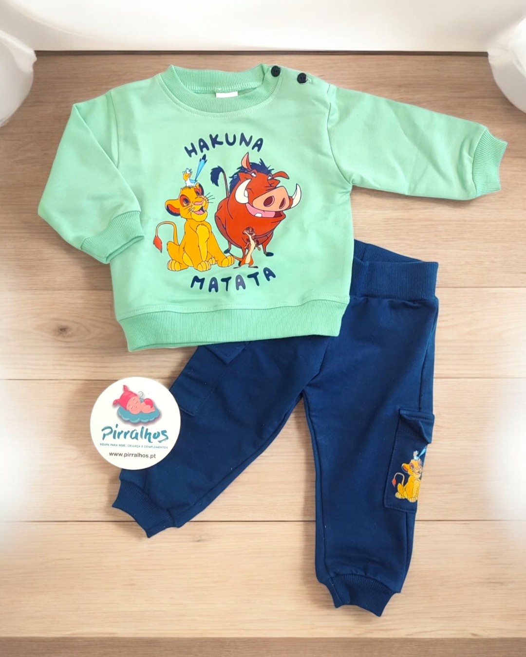 Conjunto infantil verde com estampa Timão e Pumba e calças azuis com estampa Simba.
