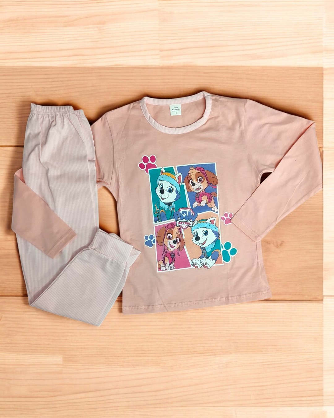 Pijama infantil rosa com estampado de cães e calças bege com joelheiras cor-de-rosa