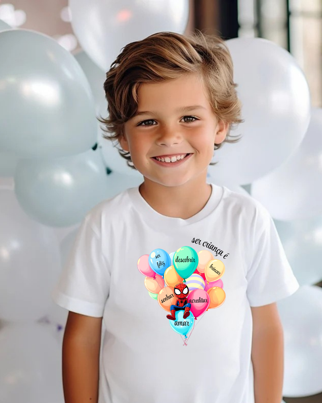 Menino com camisola branca estampada de balões coloridos e texto em português