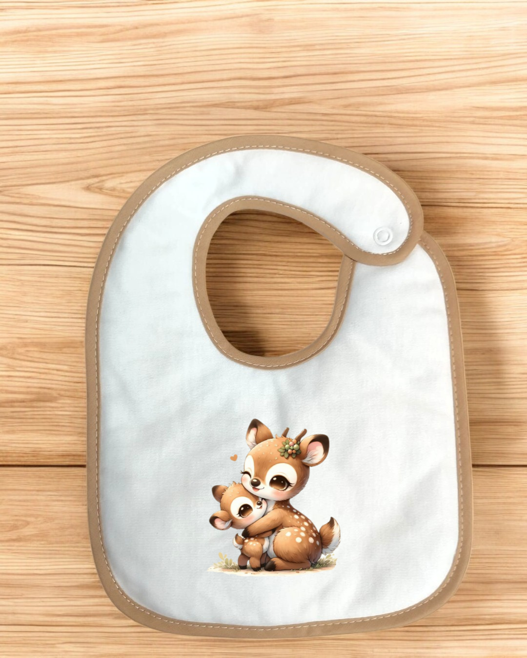 Babete branco com borda bege e desenho de duas corças abraçadas