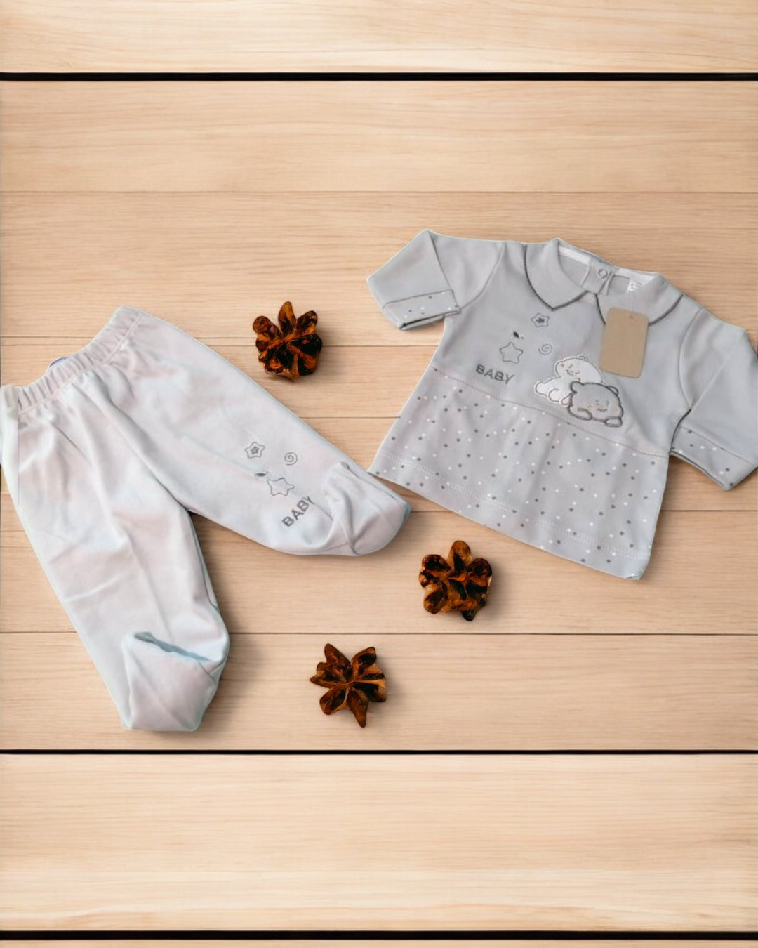 Conjunto de roupa cinzenta para bebé com estampado de nuvem e estrelas sobre madeira clara