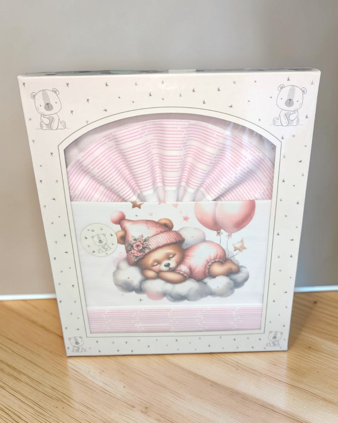 Conjunto de roupa de bebé rosa com ursinho adormecido na embalagem decorada