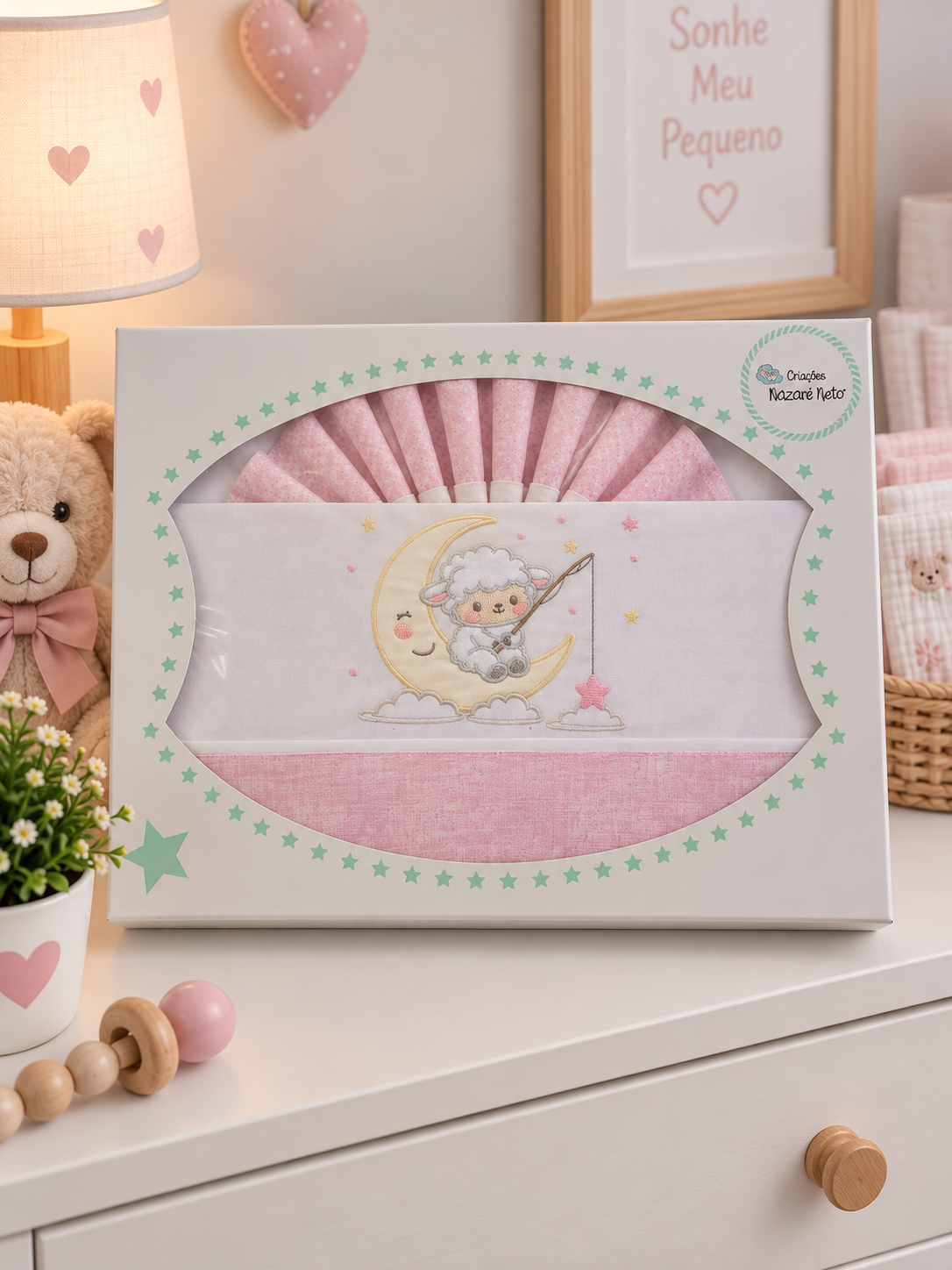 Conjunto de roupa de cama rosa para bebé com bordado de ovelha na lua numa caixa branca com estrelas verdes