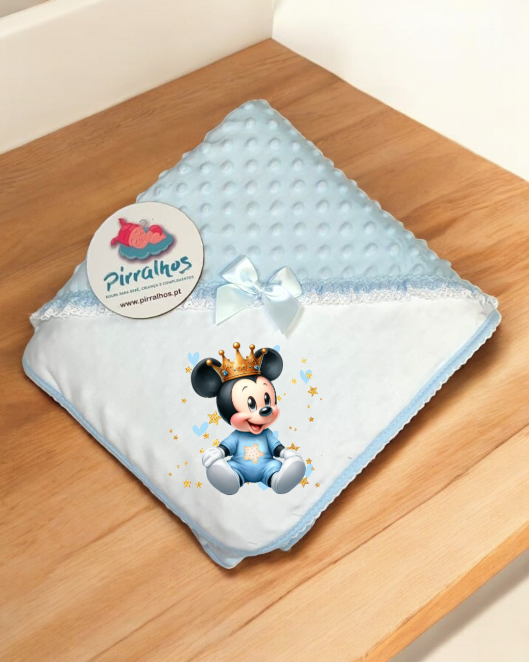 Manta para bebé azul e branca com estampa do Mickey e etiqueta da marca Pirralhos