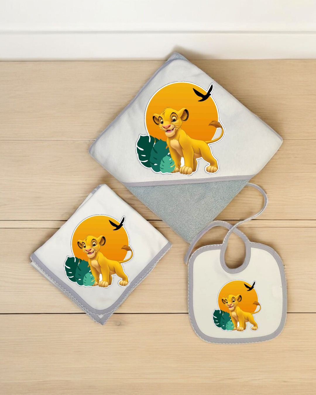Conjunto de toalha de banho com capuz, fralda e babete para bebé com personagem Simba do Rei Leão em fundo alaranjado