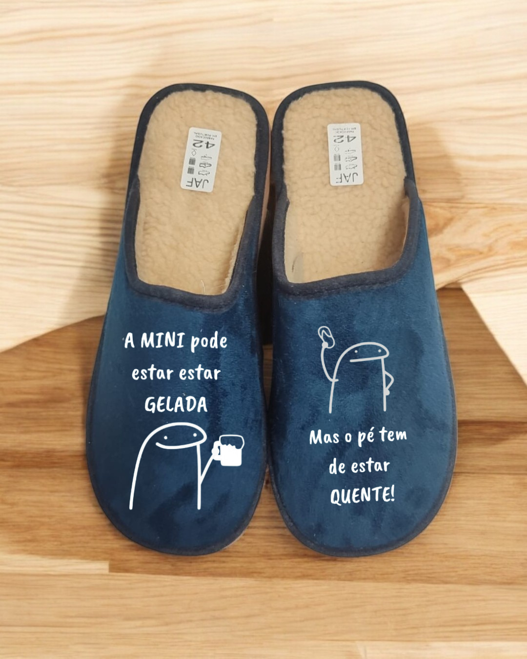 Chinelos azuis com texto e desenhos brancos, interior felpudo creme, tamanho 42