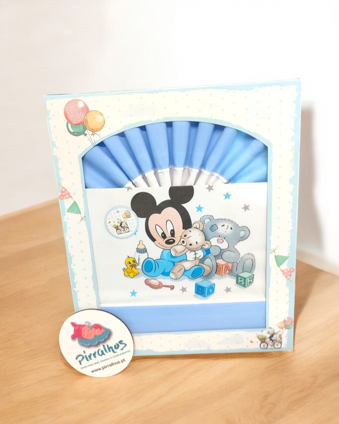 Cortina azul bebe com personagens animados e embalagem decorativa.