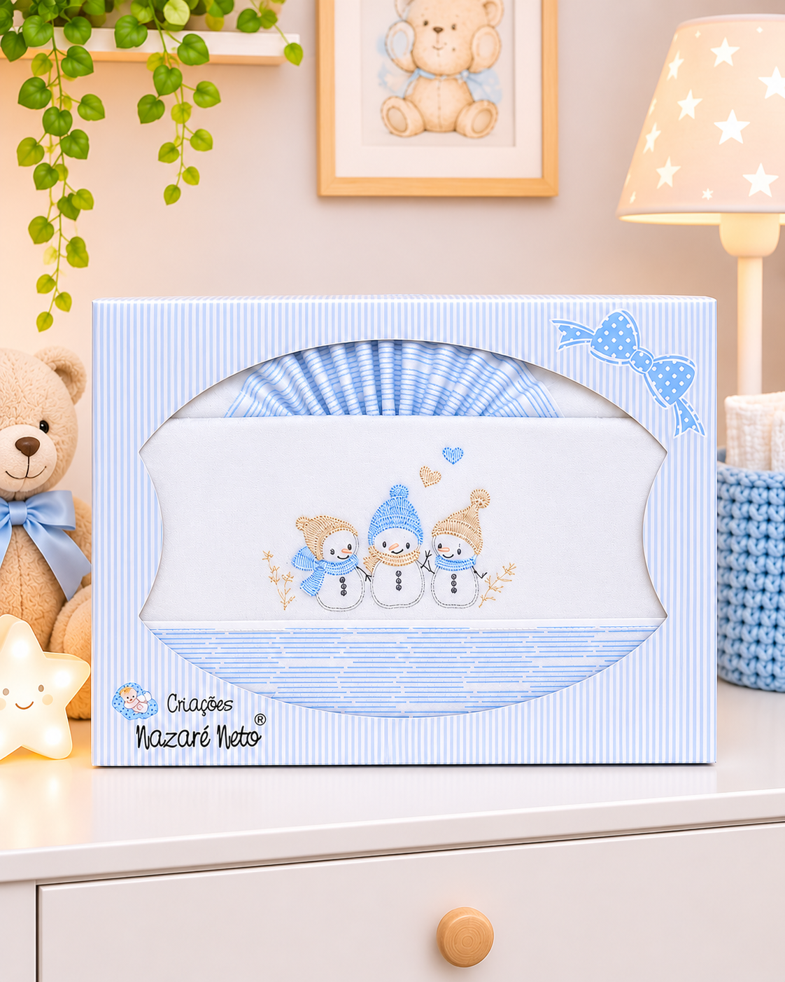 Conjunto de roupa de bebé embrulhado em embalagem azul clara com riscas e bordado de bonecos de neve