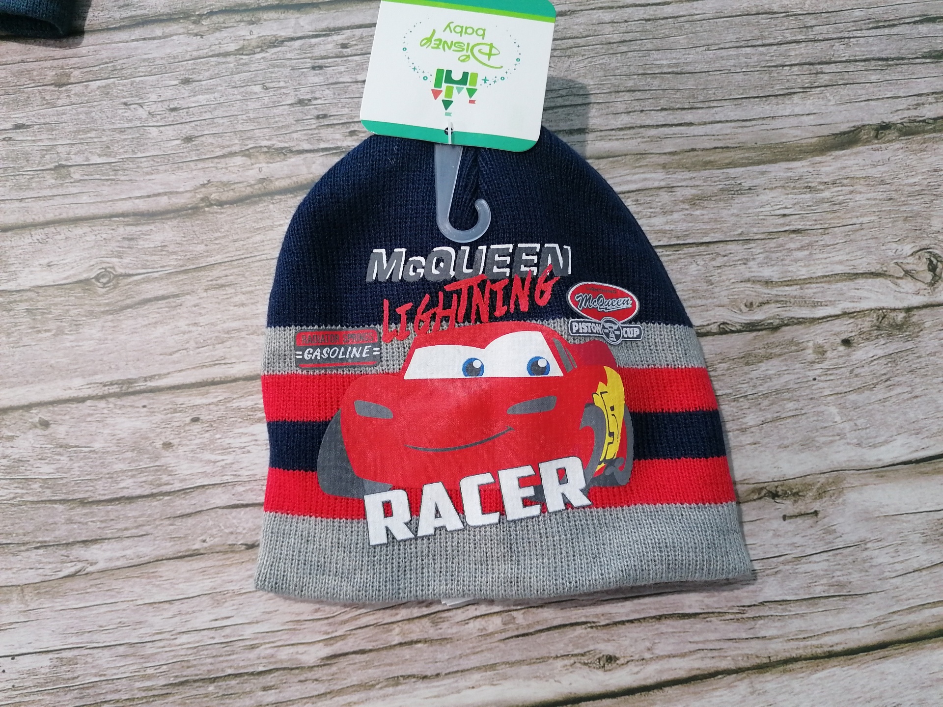 Gorro de malha com riscas azul, vermelho e cinzento com imagem do Lightning McQueen e texto