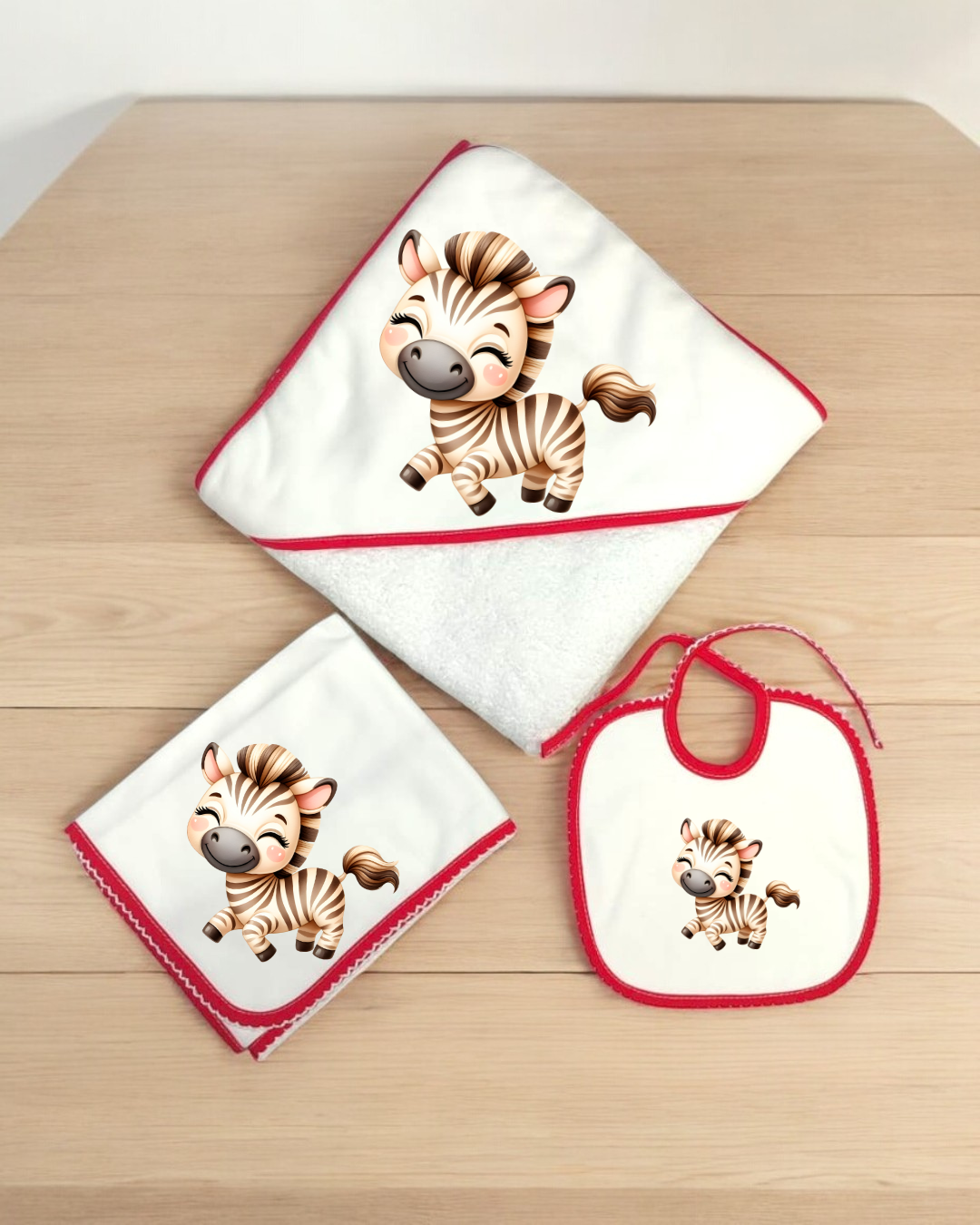 Conjunto de toalha de bebé com zebra, babete e fralda em branco com bordas vermelhas
