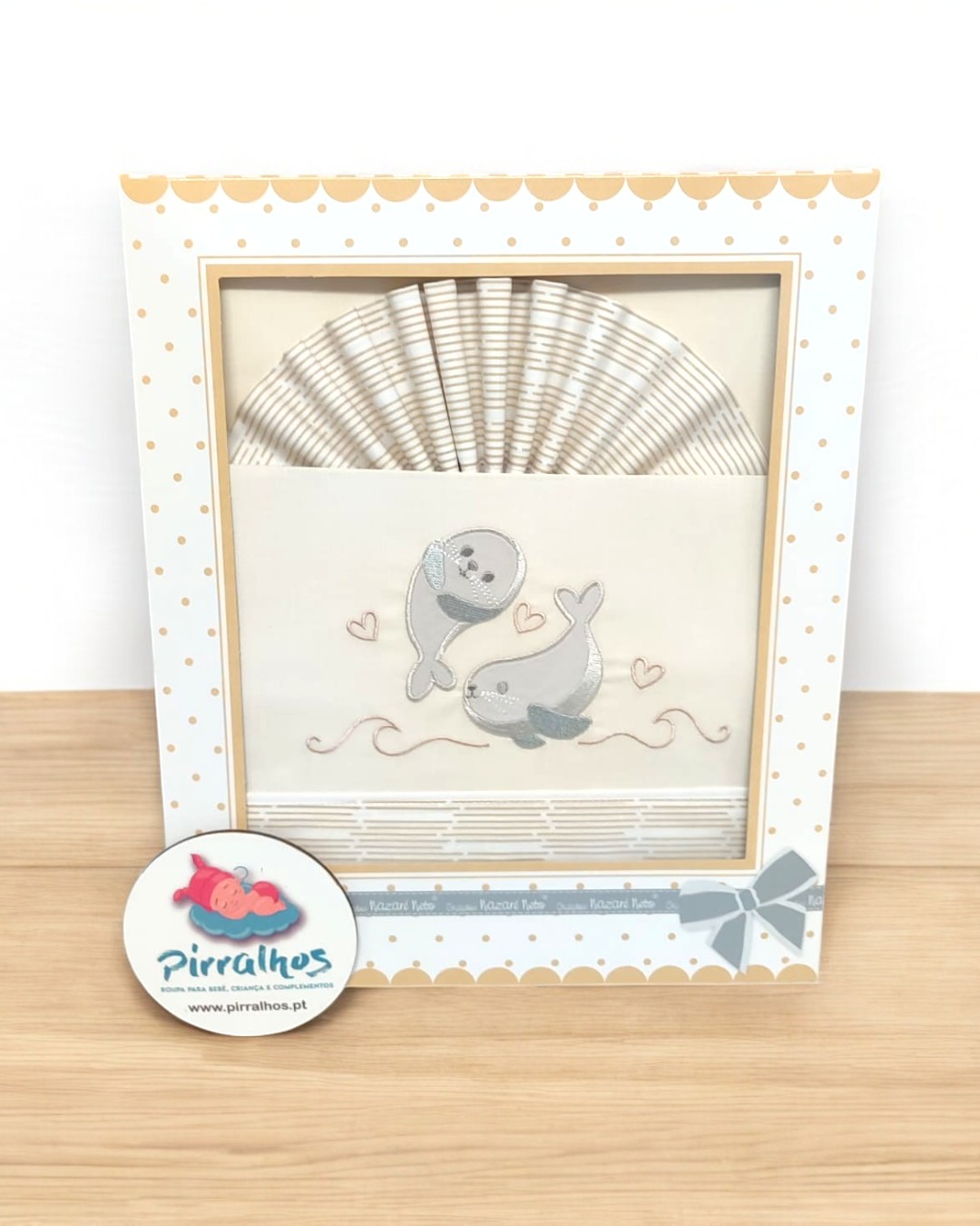 Conjunto de fraldas com desenho de focas numa caixa decorada, etiqueta da marca Pirralhos