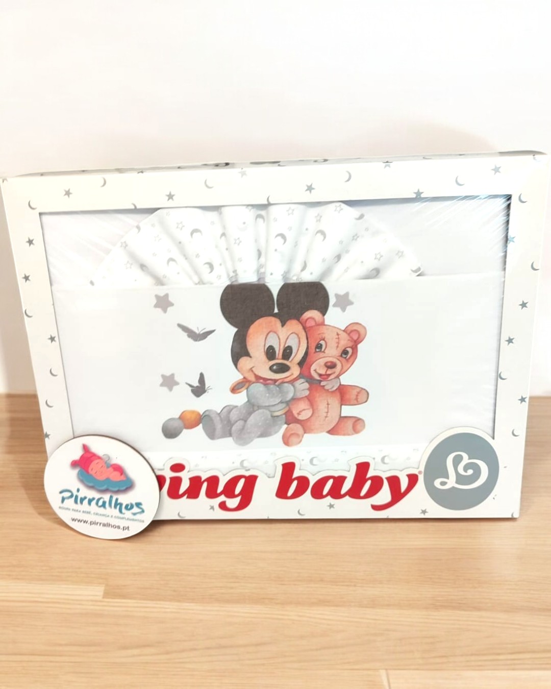 Conjunto para bebé branco com ilustração de rato e urso abraçados em embalagem.