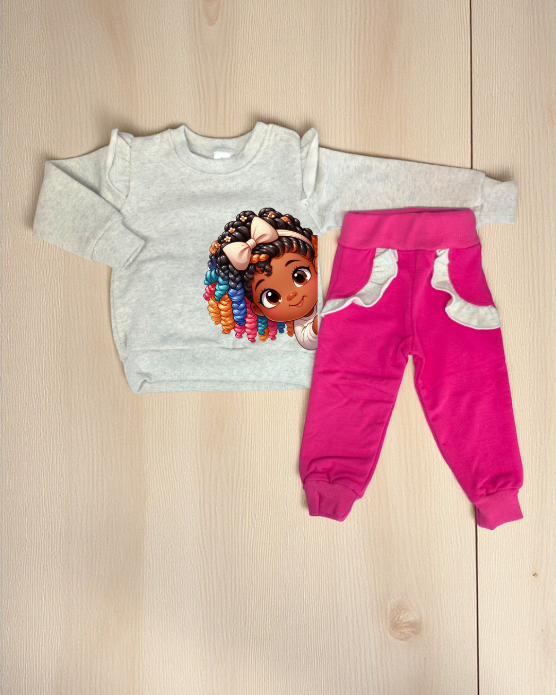 Conjunto roupa infantil com camisola cinza estampada e calças rosa com detalhes cinza