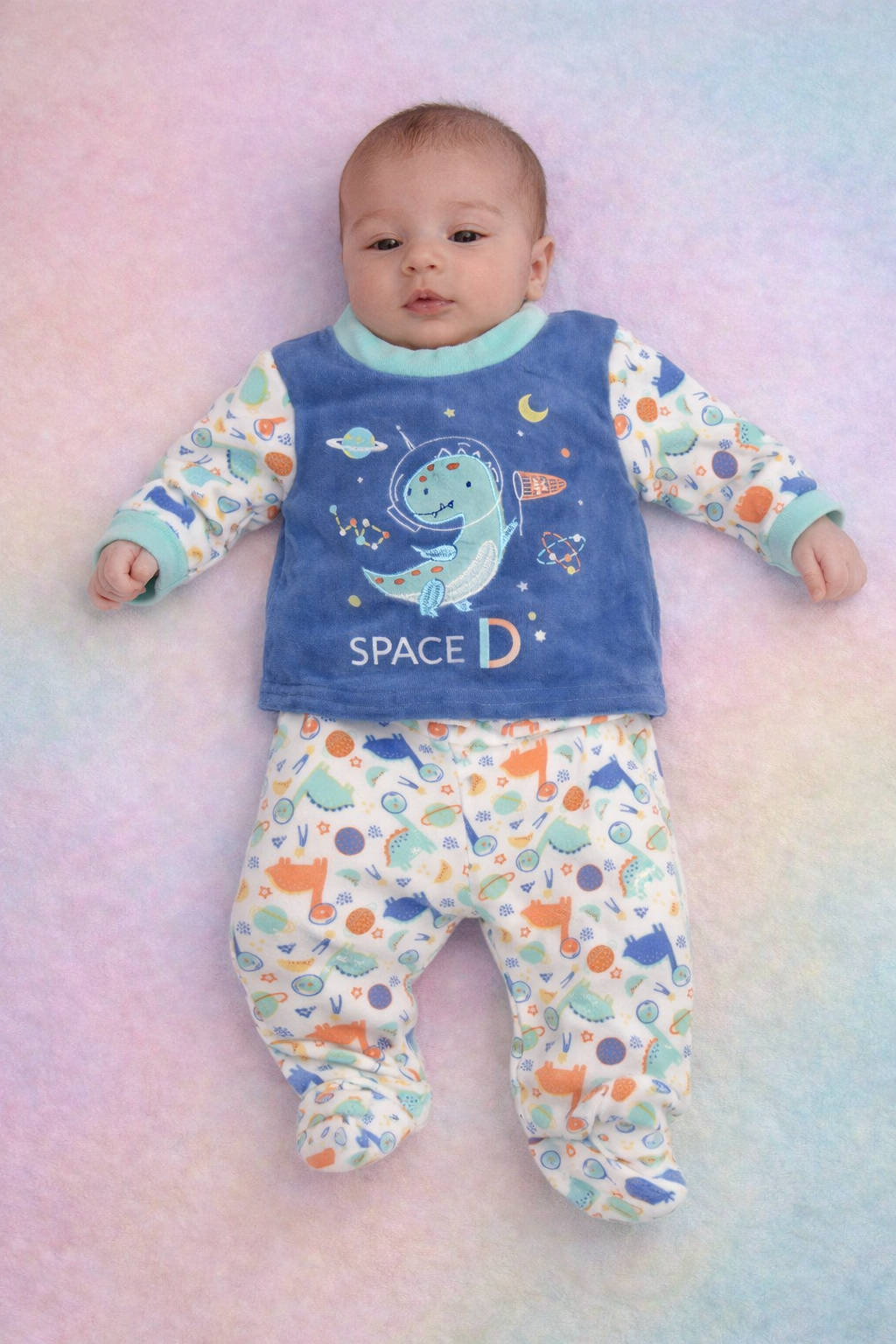 Pijama de bebé azul e branco com padrão espacial e dinossauro