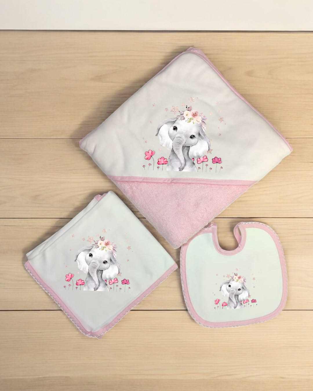 Conjunto de três artigos de bebé rosa e branco com elefante decorativo.