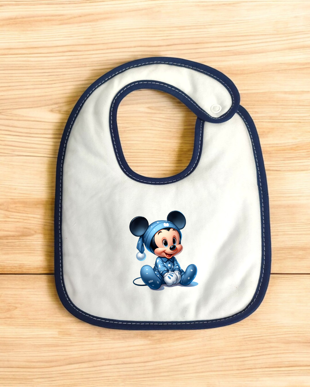 Babete branco com imagem de bebé Mickey Mouse num pijama azul