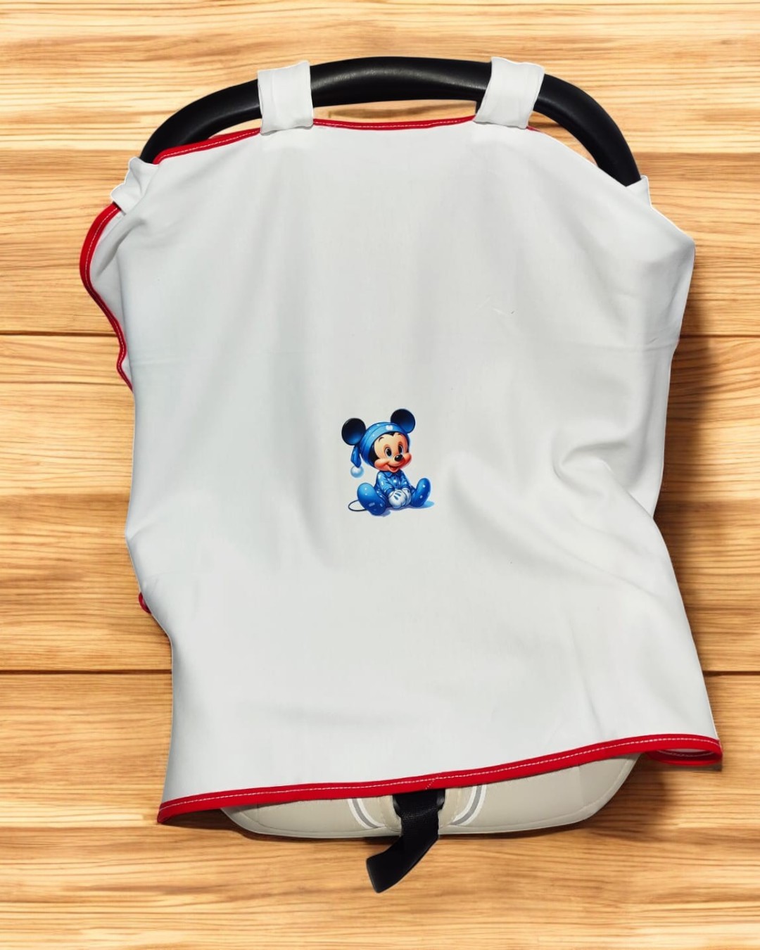 Capa protetora branca para assento de bebé com bordas vermelhas e imagem de Mickey Mouse.