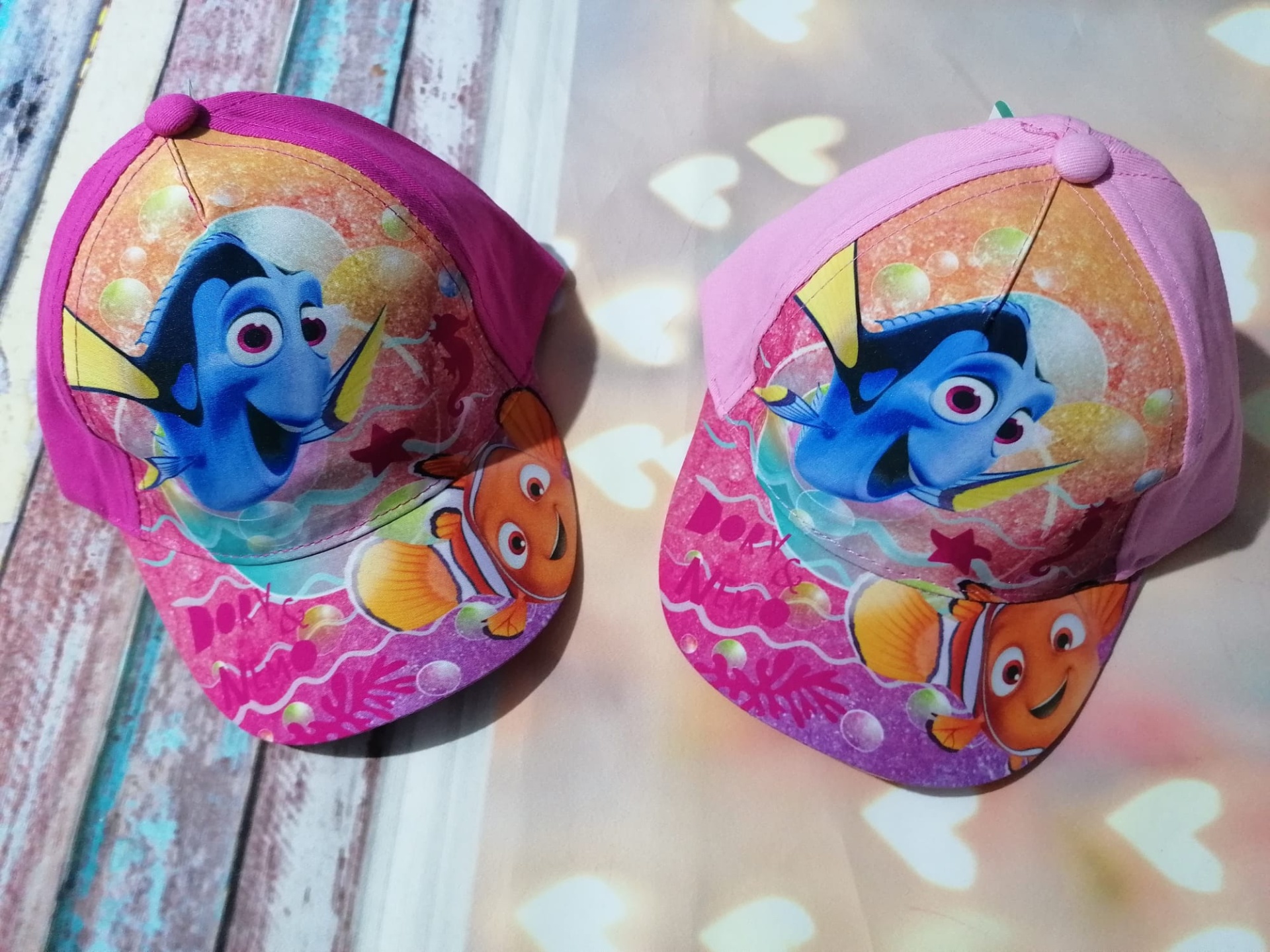 Duas chapéus de criança cor-de-rosa com personagens Dory e Nemo do filme 'Procurando Nemo'.