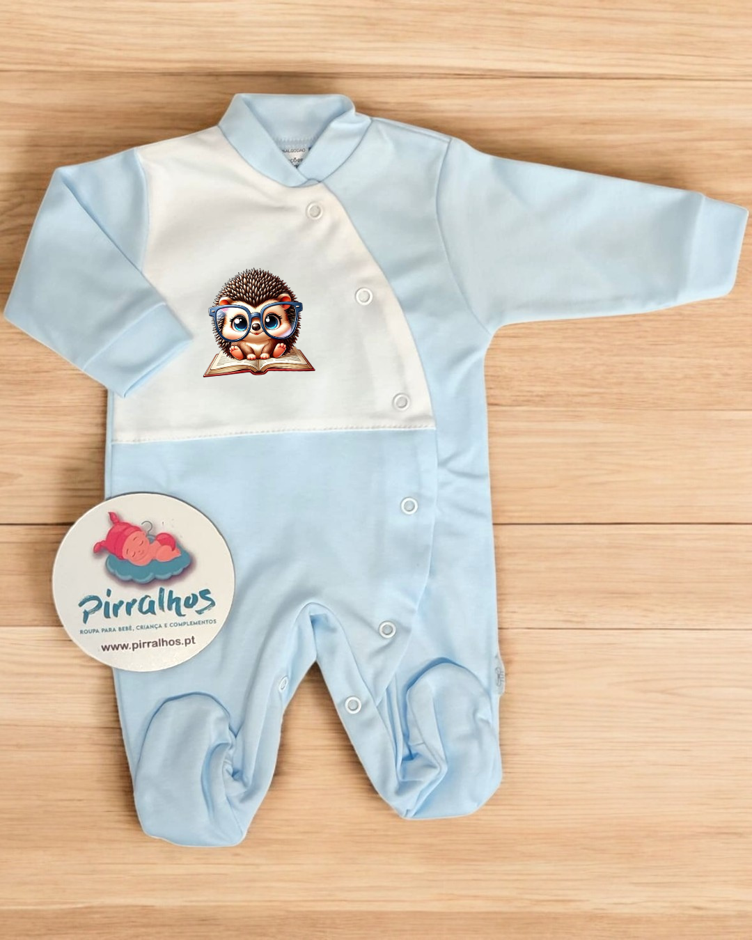 Macacão de bebé azul e branco com estampa de ouriço com óculos sentado em livro
