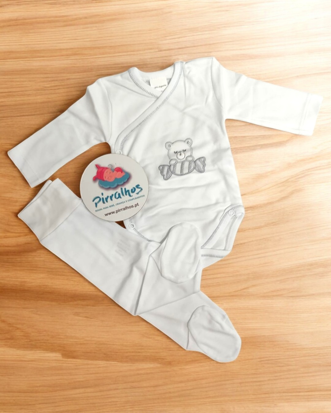 Conjunto de roupa de bebé branco com body e calças, ursinho cinzento bordado.