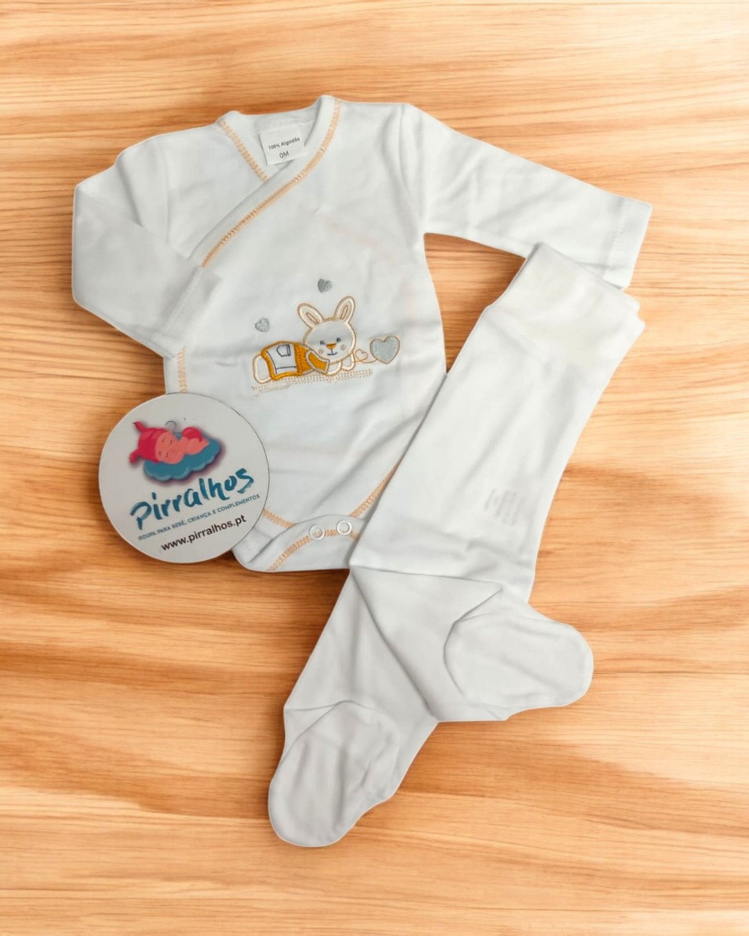 Conjunto de roupa de bebé branco com bordado de coelho e etiqueta redonda da marca Pirralhos