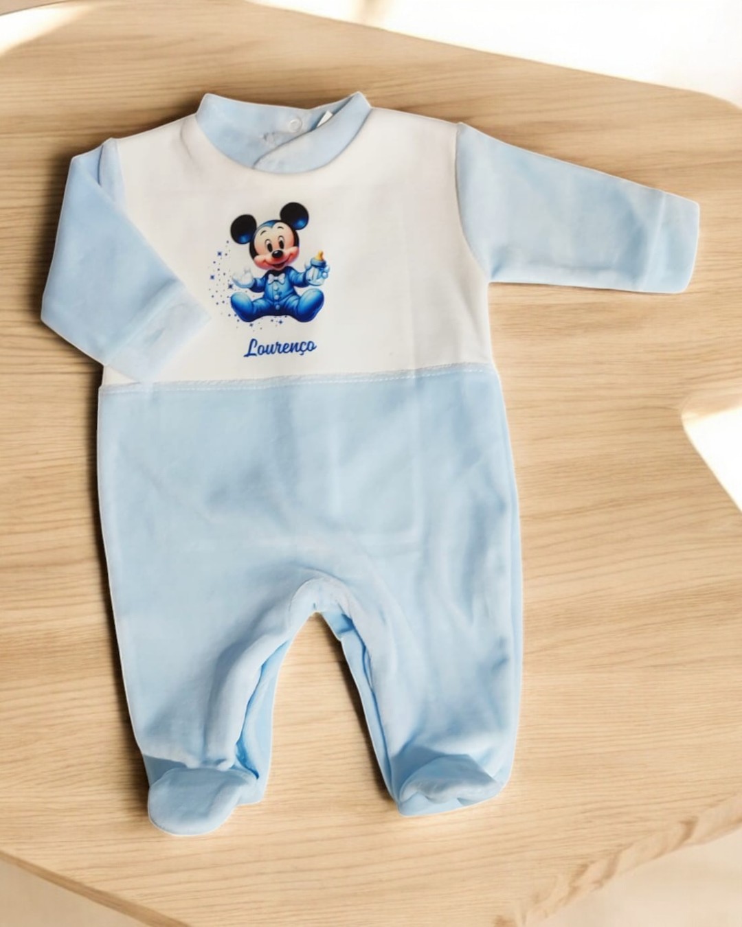 Macacão de bebé azul claro e branco com imagem do Mickey Mouse e texto Lourenço