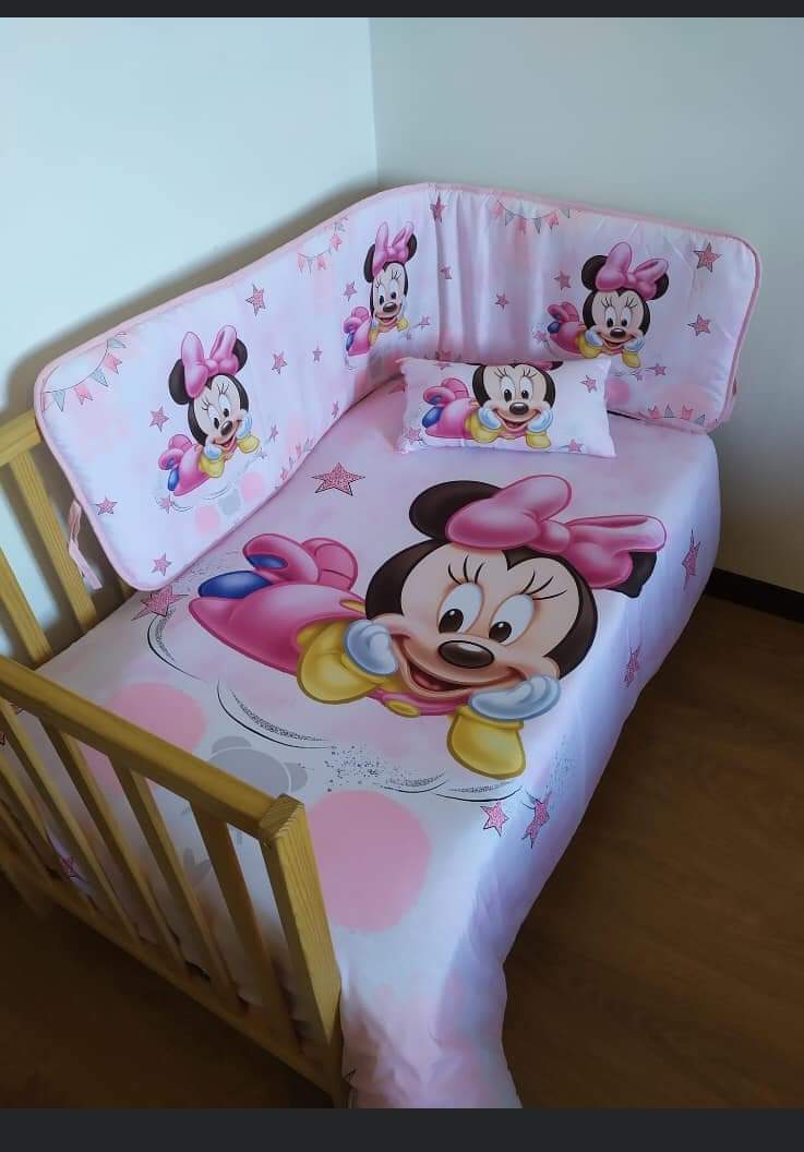 Cama infantil de madeira com roupa de cama rosa da Minnie Mouse