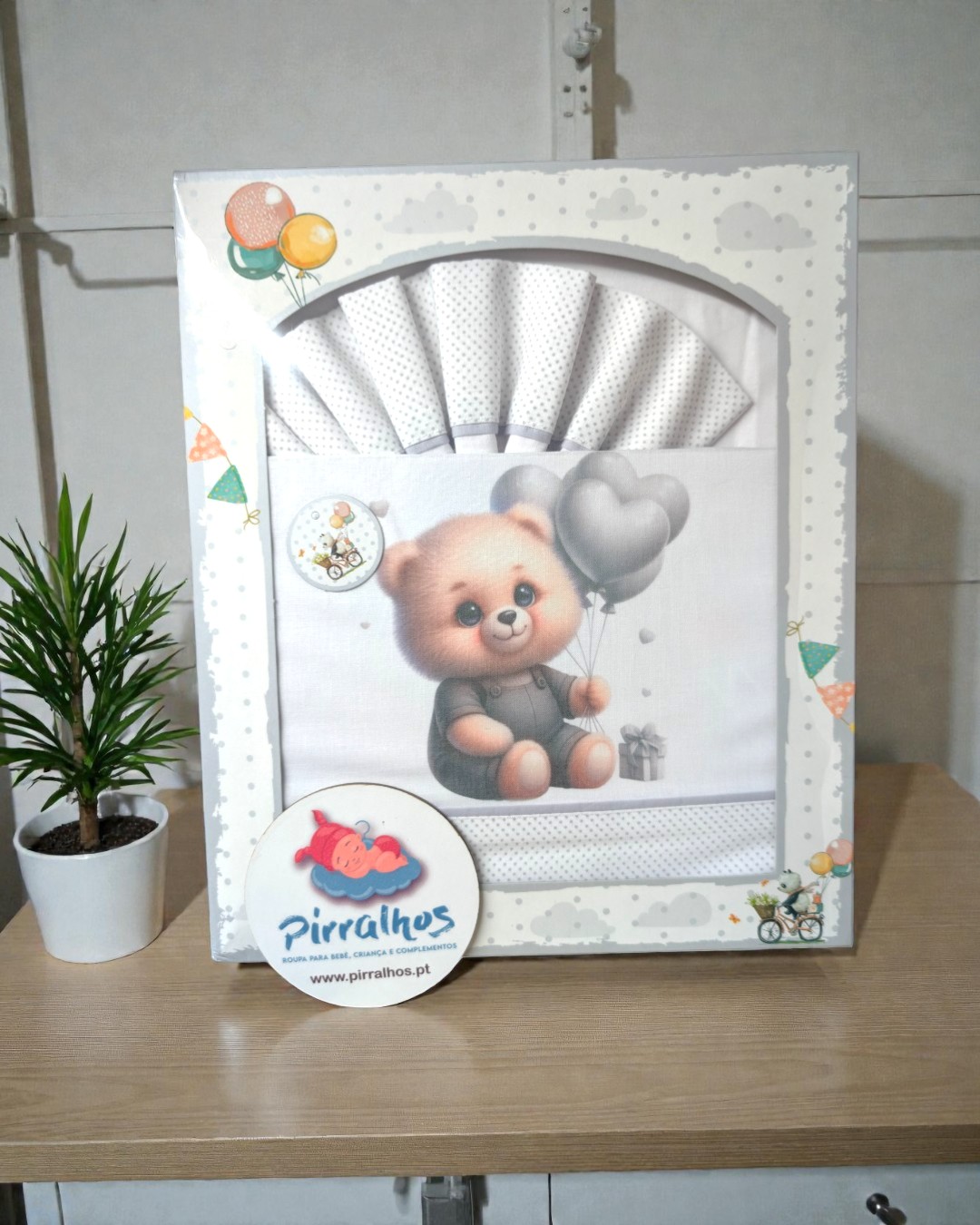 Conjunto de roupa para bebé com desenho de ursinho e balões dentro de embalagem decorativa