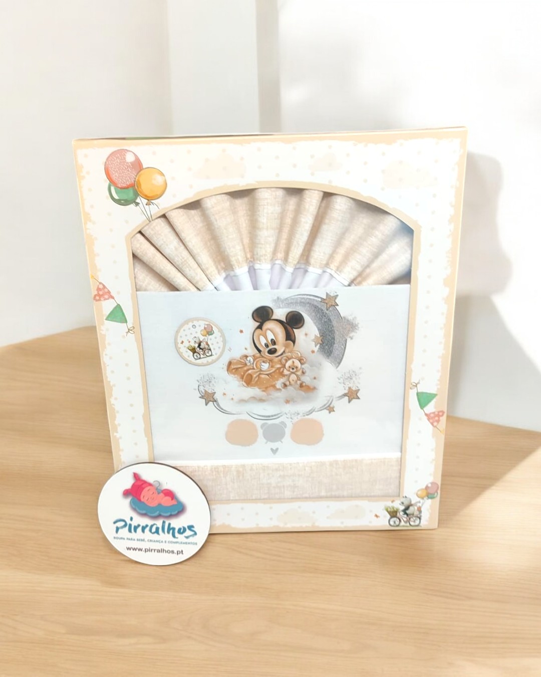 Fralda decorativa para bebé com estampa de Mickey Mouse em caixa de embalagem bege e branca.