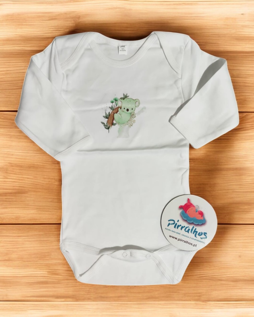 Body de bebé branco com estampa de coala e etiqueta redonda da marca