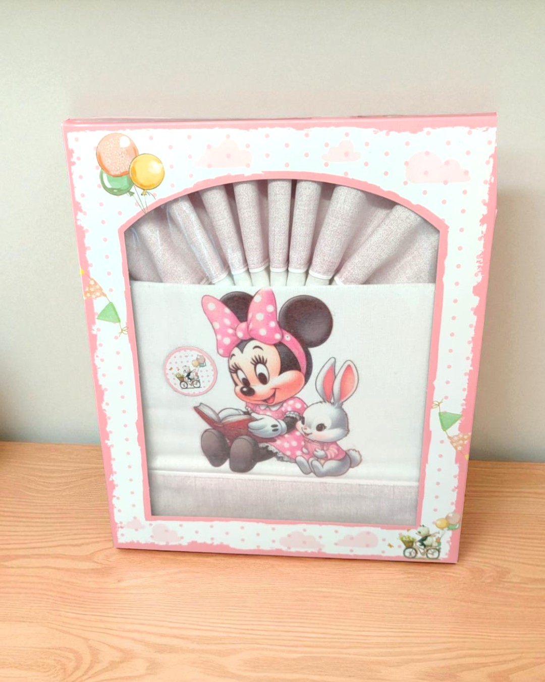 Fato de berço ou roupa de cama para bebé com aplicação da Minnie Mouse e coelho, embalado em caixa rosa decorativa.