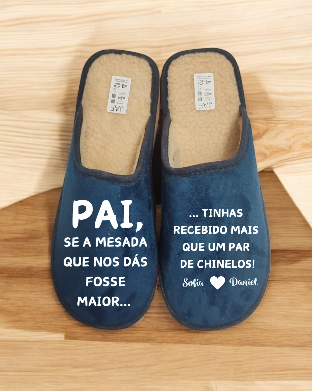 Par de chinelos azuis com texto branco e interior peludo bege, etiquetas de tamanho 42