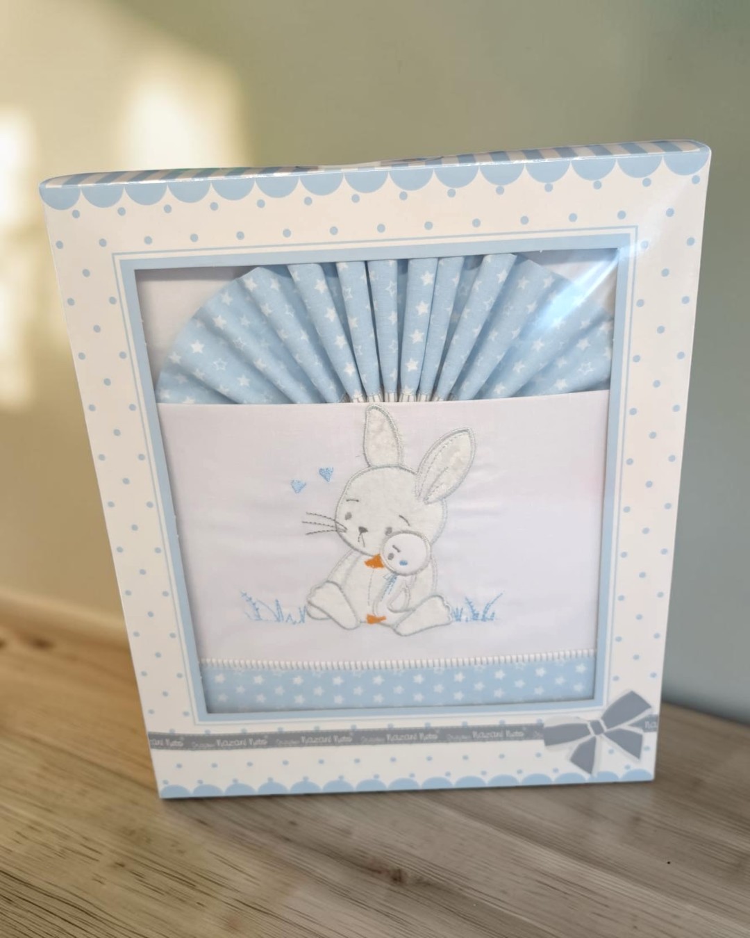 Conjunto de têxteis para bebé azul claro com bordado de coelho em embalagem decorada.