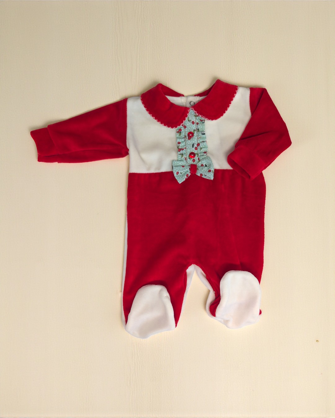 Macacão bebé vermelho e branco com detalhes azuis sobre fundo claro