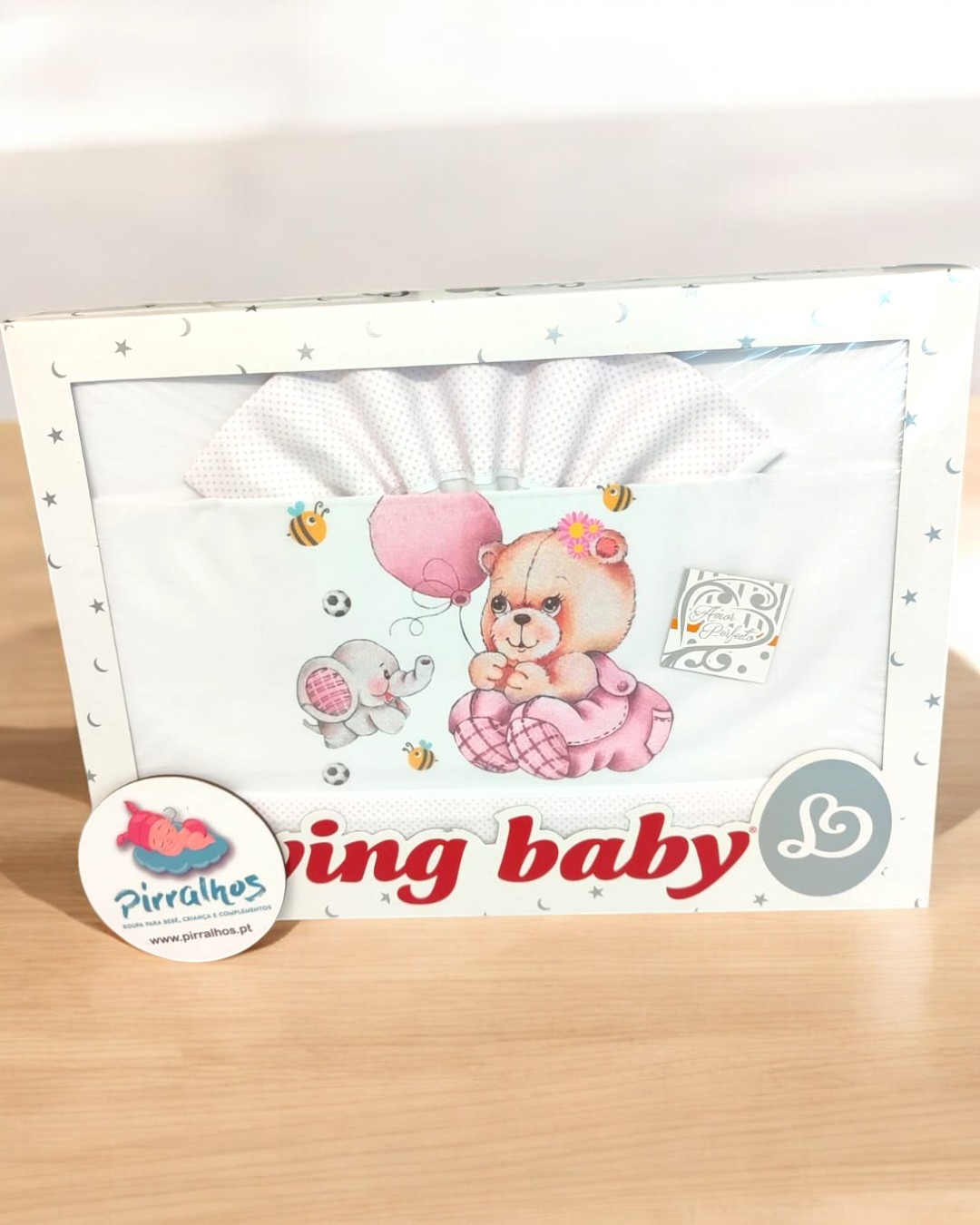 Caixa de roupa de bebé branca com ursinho e ratinho desenhados e texto parcial 'ing baby'