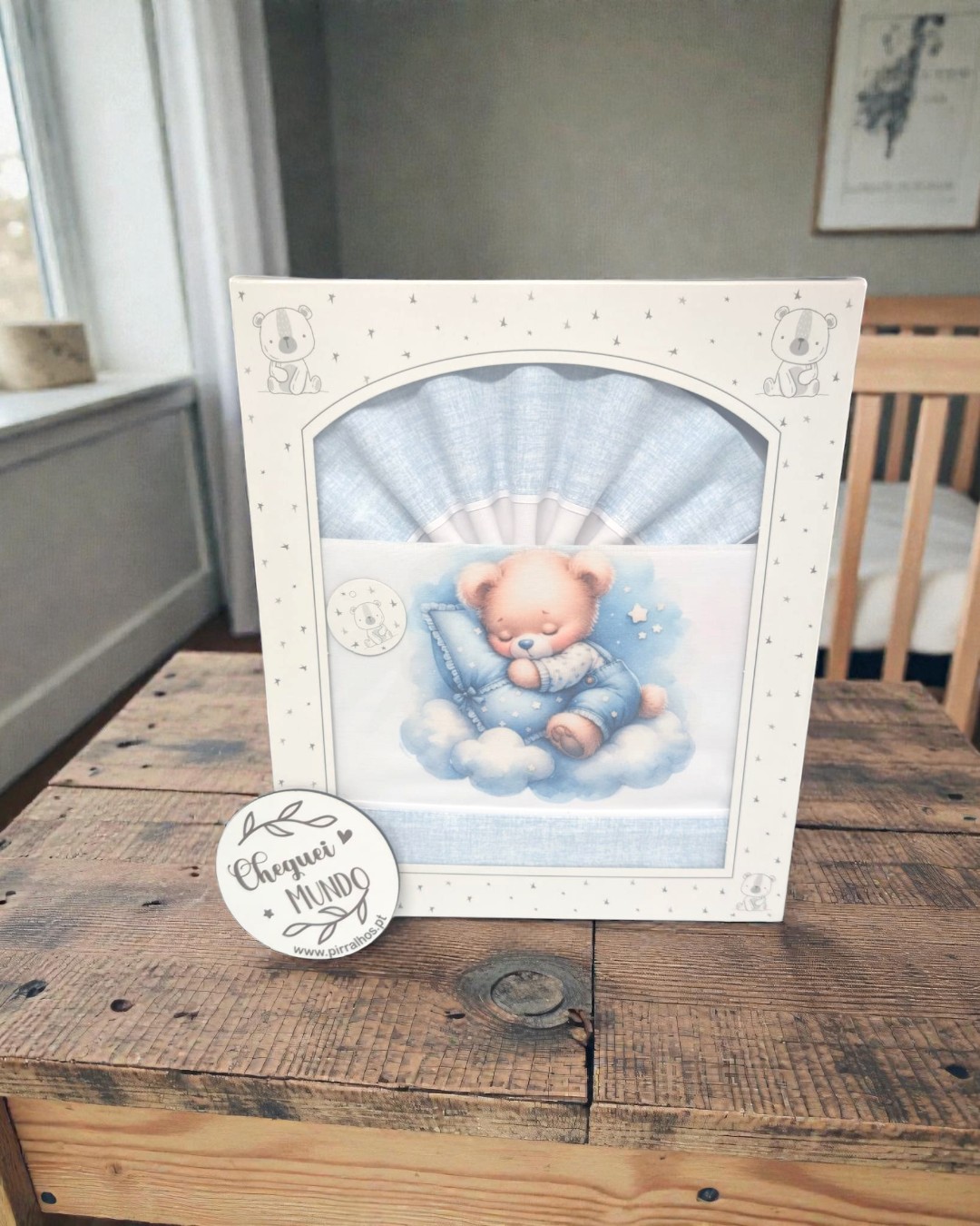 Conjunto de roupa de bebé azul claro com ursinho a dormir em nuvem e embalagem decorada com ursinhos e estrelas.