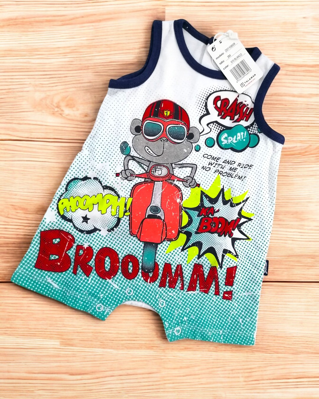 Macacão de bebé com desenho de macaco em mota vermelha e onomatopeias coloridas.