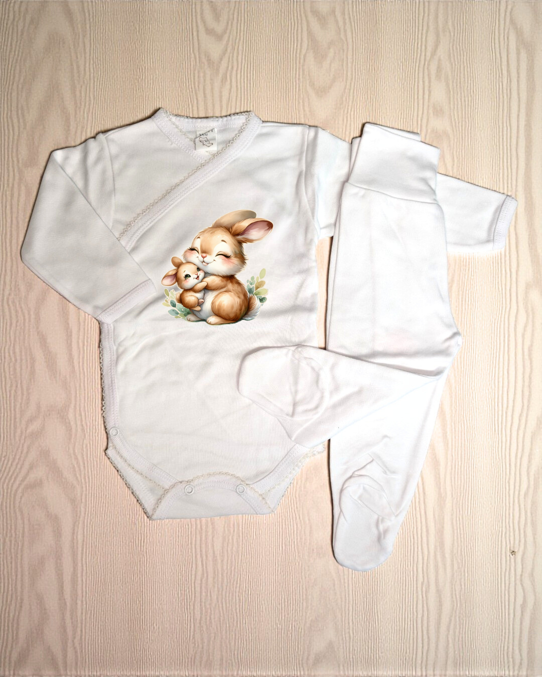 Conjunto de roupa de bebé branca com padrão de coelhos