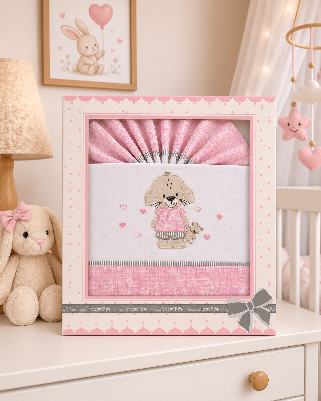 Caixa de jogo de cama de bebé rosa e branco com bordado de cão em ambiente de quarto infantil