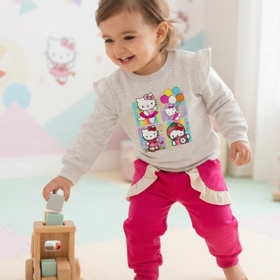 Criança vestindo roupa infantil Hello Kitty, a brincar com brinquedo de madeira em ambiente colorido e lúdico