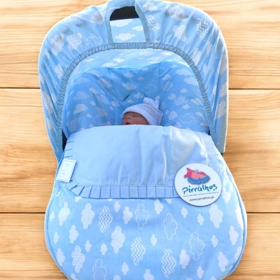 Saco de dormir azul para bebé com padrão de nuvens e boneco com gorro