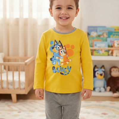Criança vestindo camisola amarela Bluey e calças cinza num quarto infantil