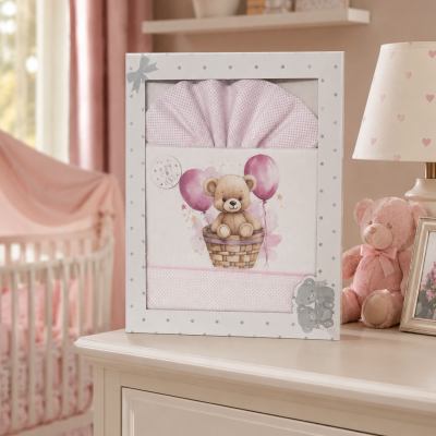 Caixa com jogo de cama para bebé com desenho de ursinho e balões cor-de-rosa.