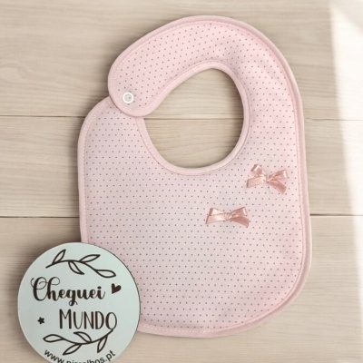 Babete cor-de-rosa claro com laços e placa redonda com texto Cheguei MUNDO