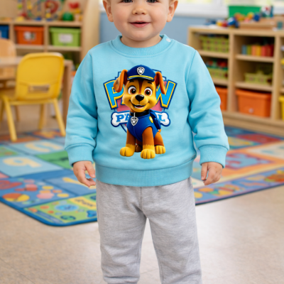 Criança com sweatshirt azul claro e calças cinza em sala de aula colorida