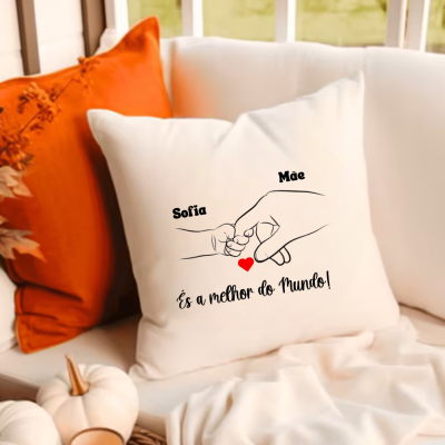 Almofada branca com mãozinhas e texto carinhoso numa sala com decoração acolhedora