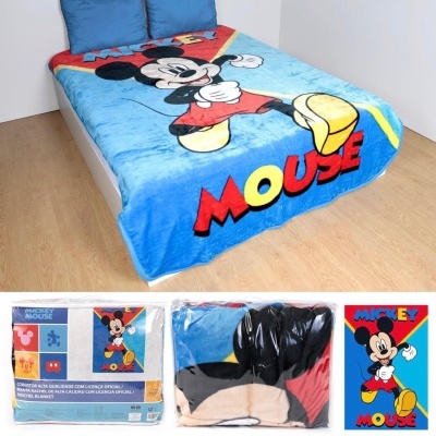 Cobertor azul com imagem do Mickey Mouse e texto MICKEY MOUSE numa cama com duas almofadas azuis