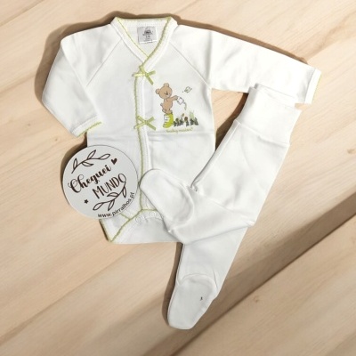 Conjunto de bebé branco com camisola de urso e calças com pés sobre madeira clara